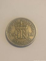 Reverse side of 1948 sixpence coin showing crown, 'GRI' initials, year 1948, and denomination 'SIXPENCE'.