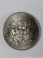 Front side of the 1985 Canadian 50 cent coin showing the Canadian coat of arms and inscriptions.