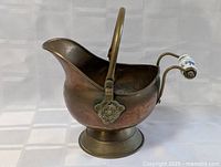 Copper coal scuttle with brass base and handle, porcelain grip, lion's head motif on side