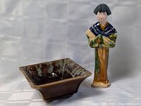 Photo showing the glazed square pottery dish and Asian-inspired pottery sculpture side by side on a white background.