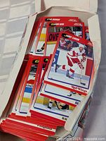 Top view of hockey cards laid inside the box showing multiple red-bordered cards featuring players such as Jimmy Carson