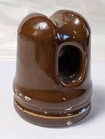 Front angled view showing the oval opening and glossy brown surface with minor chips.