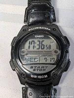 Close-up showing the digital watch face with time, date, and text labels.