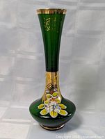 Front view of the green Bohemian crystal glass vase showing the 24K gold and hand-painted floral decoration on the body and neck.
