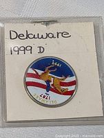 Front side of Delaware 1999 D colored state quarter coin in holder.
