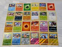 Photo showing full spread of 27 Pokemon cards including character and energy cards.