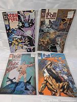 Four comic books laid out, showing full covers with notable characters and title text, in protective sleeves.