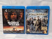 Front view of two Blu-ray cases: 'No Country for Old Men' and 'Stalingrad'