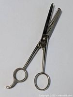 Full view of the hairdresser thinning shears showing the entire tool including handles and blades.