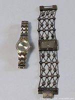 Photo showing two women's watches side by side on a white background; left is a silver-tone round-faced watch with linked bracelet, right is a rectangular-faced watch with an open lattice metal bracelet.