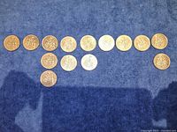 All 14 Canadian 50-cent coins laid out on blue surface