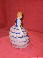 Side view of porcelain lady figurine showing layered skirt detail
