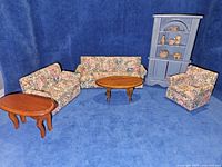 Full set arranged showing sofa, loveseat, armchair, two tables, blue hutch with pottery