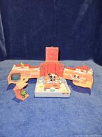 Overall view of fold-out playset with panda figure on center platform, fish figure on side, frog figure in gazebo