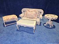 Group shot of sofa, two tables, footstool, cushions