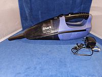Full view of Shark handheld vacuum with charger