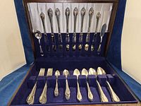 Open flatware chest showing full set arranged in slots