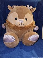 Front view of large plush reindeer showing face, body shape and metallic lavender accents
