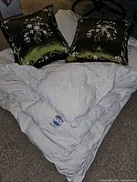 Duvet folded with two satin pillows on top