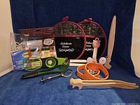 Group shot of all 15 kitchen utensils and accessories laid out on blue background