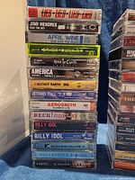 Left-side stack of 15 labeled cassettes featuring artists such as Hendrix, April Wine, Alice in Chains, Aerosmith, Beck, Billy Idol and others