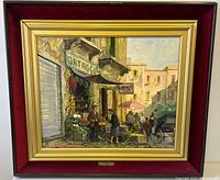Full view of framed oil painting showing market scene with vendor, customers, carriage and background buildings