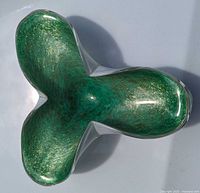 Top down view of the green Murano glass bowl shaped like a cloverleaf with gold spangled decoration inside.