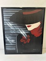 Framed canvas art print showing a profile of a woman in black hat and red scarf with a red flower and smoke in front of a window with blinds.