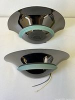 Pair of curved chrome wall sconces with ribbed glass rings on a white background.