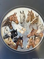 Close-up of circular watercolour painting showing twelve horse heads arranged in a ring with two human hands holding reins in the center, signed by the Alderson sisters dated 1940.