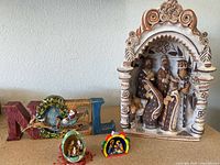 Full display showing handcrafted nativity, painted NOEL sign, and two miniature nativity ornaments.
