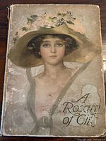 Front cover of the 1913 book 'A Rosary of Girls' showing a painted portrait of a young woman with a large hat, the title is printed on the lower right.