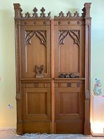 Front view of tall double-door style solid wood wall panel with detailed Gothic style carved foliage and floral patterns, decorative cresting along top edge.