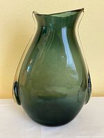 Front view of green Blenko pouch vase showing rounded body, flared asymmetrical mouth, and sculpted pouch sides.