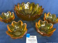 Image showing the complete five-piece set with one large bowl and four smaller bowls in amber glass with lotus petal design edges