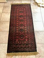 Top view of rectangular floor rug showing geometric pattern and fringes