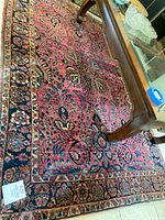 Full view of the hand woven Oriental rug showing colors and overall design pattern.