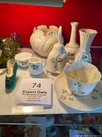 Full set on display showing all porcelain and figurines including teacup set, vases, bell, and shoe figurines.