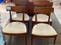 Four walnut chairs arranged in two rows, showing overall lot.