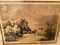 Close-up photo of the artwork showing the landscape scene with cliffs, river, and trees, with visible artist signature and date.