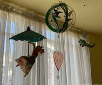 Photo showing all four hanging artwork pieces together in front of a window with light curtain.