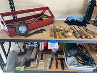 Overview of vintage tools and paint supplies including chisel tools, work gloves, and paintbrushes on shelf.