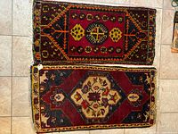 Two floor rugs arranged side by side on tiled floor, showing full pattern and size comparison