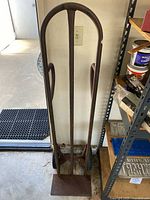 Front view of the upright hand cart leaning against a wall, showing the rusted metal frame and flat base plate.