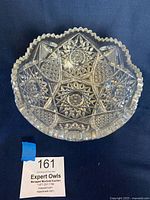 Top view of the vintage American Brilliant Cut Glass crystal bowl showing intricate starburst and geometric cut patterns and scalloped edge.