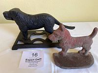 Two cast iron dog figures, showing the nutcracker and Scottie dog sculpture side by side, with auction lot tag.