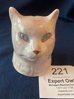 Front quarter side view of vintage ceramic cat head bank showing crackle glaze and crack on right cheek area.