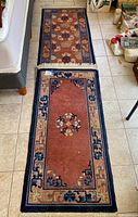 Both vintage room rugs placed on tile floor showing overall size, pattern, and design.