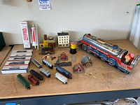 Overall view of the vintage Silver Mountain Express 3525 train set including locomotive, multiple train cars, and miniature buildings arranged on a table.