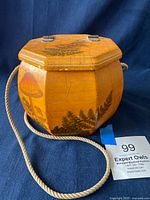 Full view of the octagonal wooden purse with visible mushroom and fern decoupage on sides and top, showing natural wood texture and rope handle.